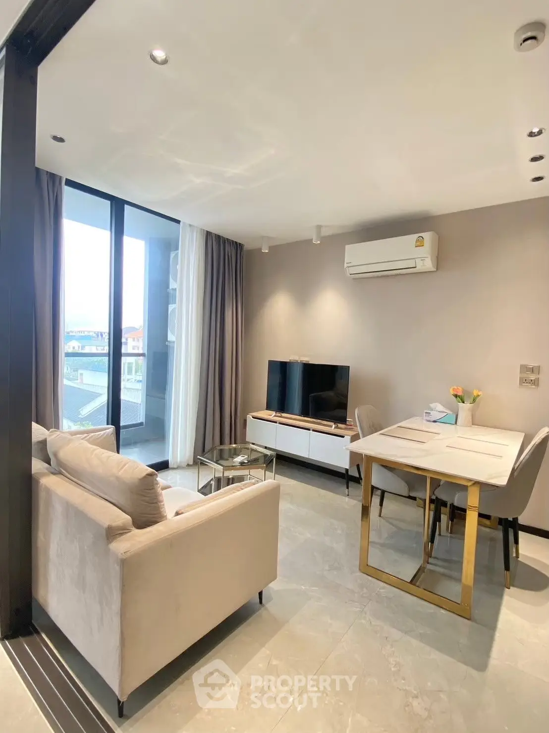 Modern living room with sleek furniture and large windows offering natural light and city views.