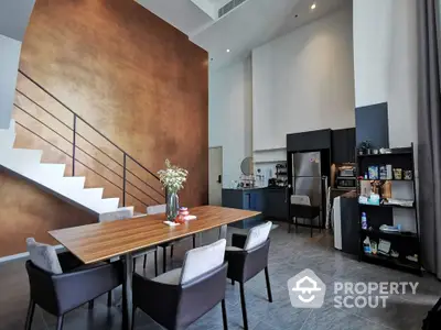 Modern dining area with high ceilings and stylish kitchen in open layout apartment