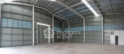 Spacious industrial warehouse with high ceilings and ample natural light.