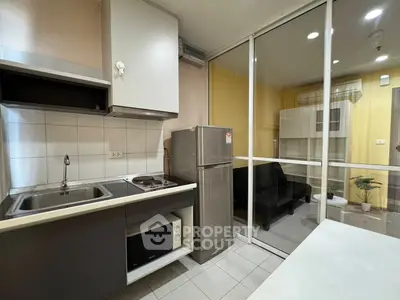 Modern kitchen with sleek appliances and open layout adjacent to cozy living area.