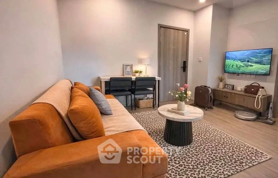 Cozy living room with orange sofa, modern decor, and wall-mounted TV in stylish apartment.
