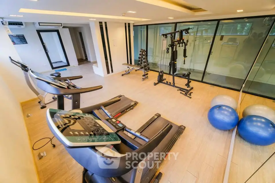 Modern gym with state-of-the-art equipment and spacious layout in luxury real estate property.