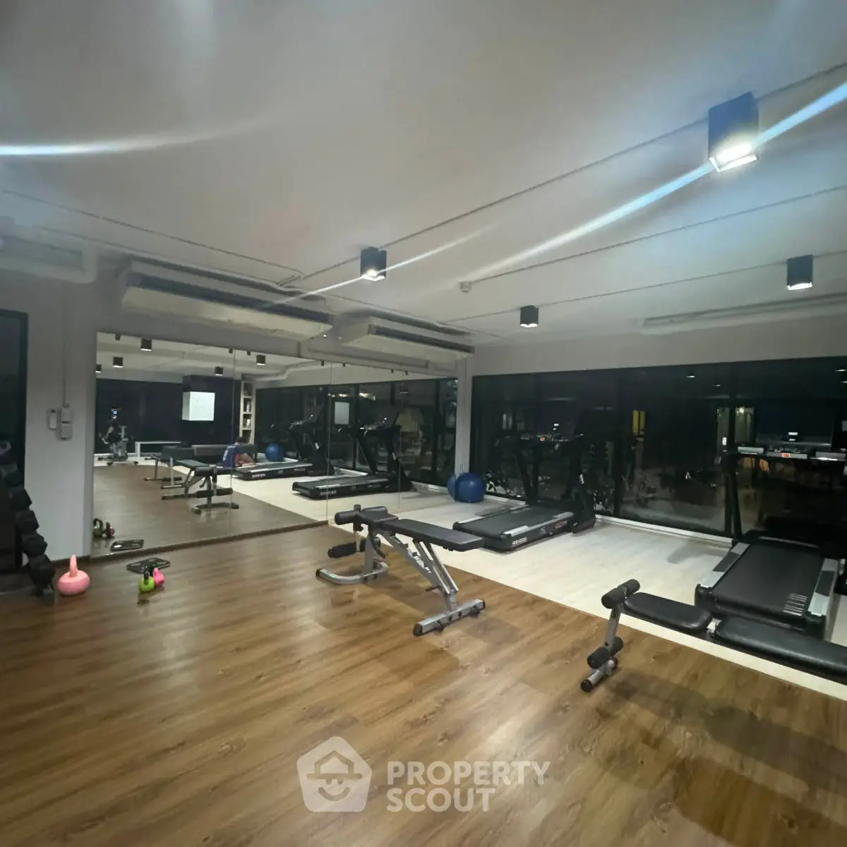 Modern gym with state-of-the-art equipment and mirrored walls in a luxury residential building.