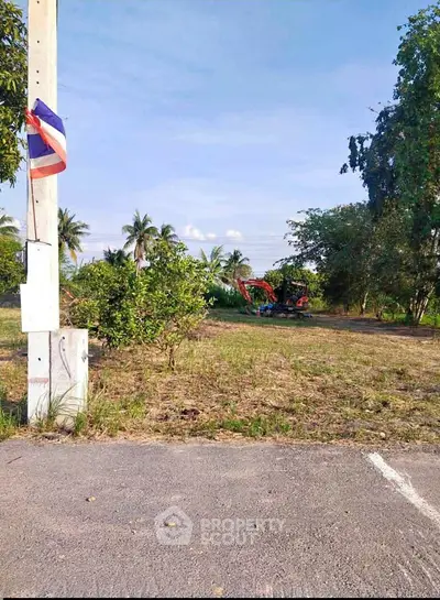 Spacious land plot with lush greenery and clear blue sky, ideal for development or investment.