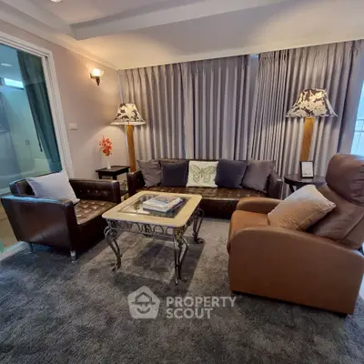 Elegant living room with leather sofas and stylish lamps, perfect for cozy gatherings.