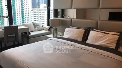 Luxurious bedroom with city view and modern decor in high-rise apartment.