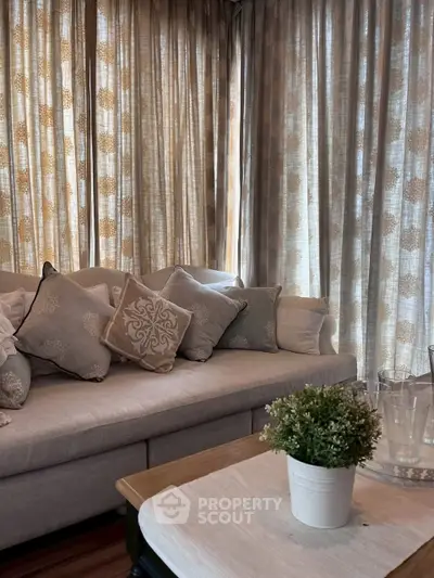 Elegant living room with plush sofa and decorative cushions, perfect for relaxation.