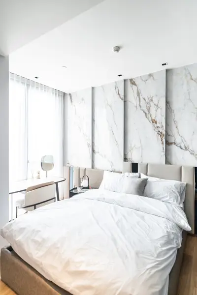 Luxurious modern bedroom with marble accent wall and natural light