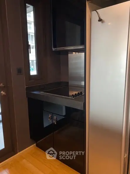 Modern kitchen with sleek appliances and gas stove in compact layout