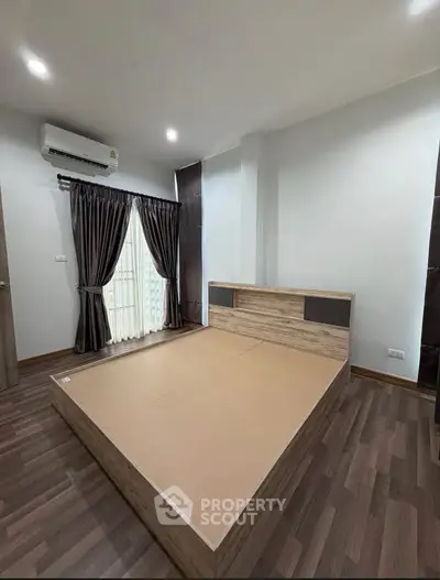 Spacious bedroom with modern design and wooden flooring