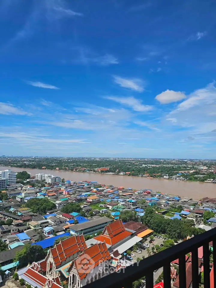 Stunning high-rise view of river and cityscape under clear blue sky.