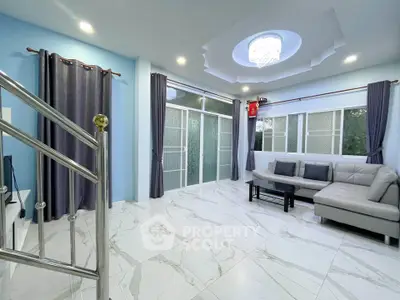 Spacious modern living room with elegant ceiling design and large windows for natural light.