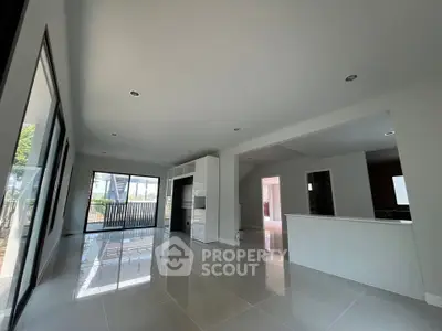 Spacious modern living room with large windows and glossy tile flooring