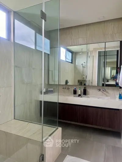 Luxurious modern bathroom with glass shower and elegant vanity.