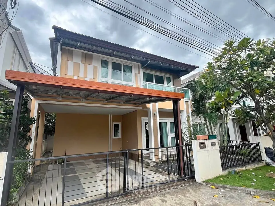 Charming two-story house with modern facade and gated driveway in a serene neighborhood.