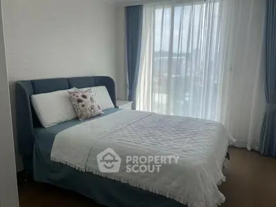 Cozy bedroom with elegant decor and large window for natural light