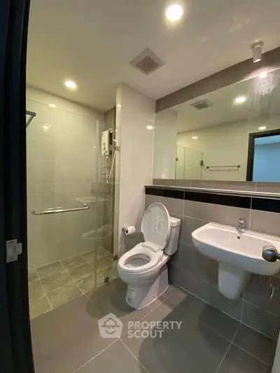 Modern bathroom with sleek fixtures and walk-in shower in a contemporary apartment.
