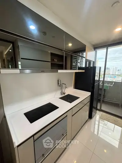 Modern kitchen with sleek cabinetry and city view from balcony