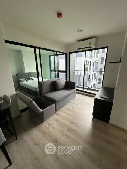 Modern apartment with open layout, featuring a cozy living room and bedroom with balcony view.
