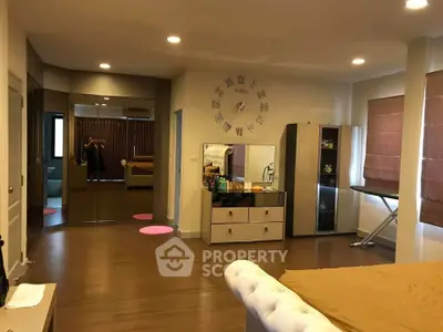 Spacious modern bedroom with wooden flooring and stylish decor