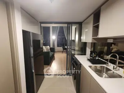 Modern kitchen with sleek appliances and open view to stylish living room