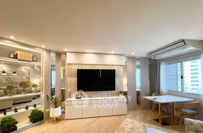 Modern living room with sleek design, large TV, and stylish furniture in a bright apartment.