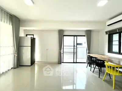 Spacious modern living room with large windows and dining area