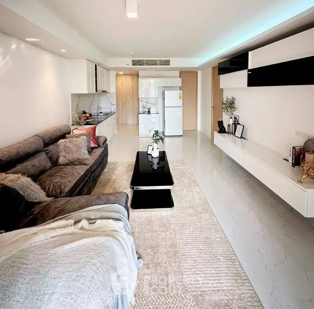 Spacious modern living room with sleek furniture and open kitchen layout