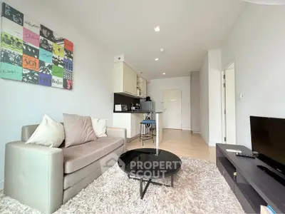 Modern living room with cozy sofa, stylish decor, and open kitchen layout in a bright apartment.