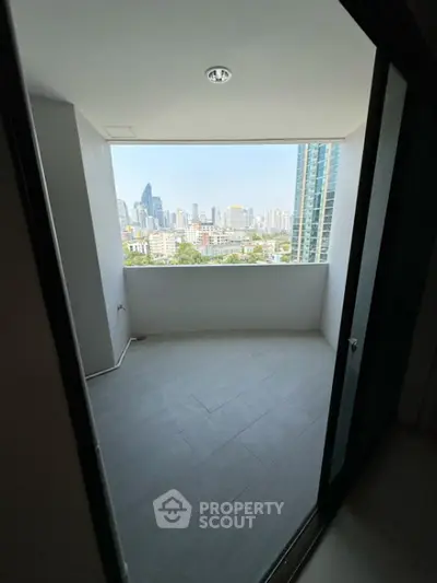 Spacious balcony with stunning city skyline view in modern high-rise apartment.