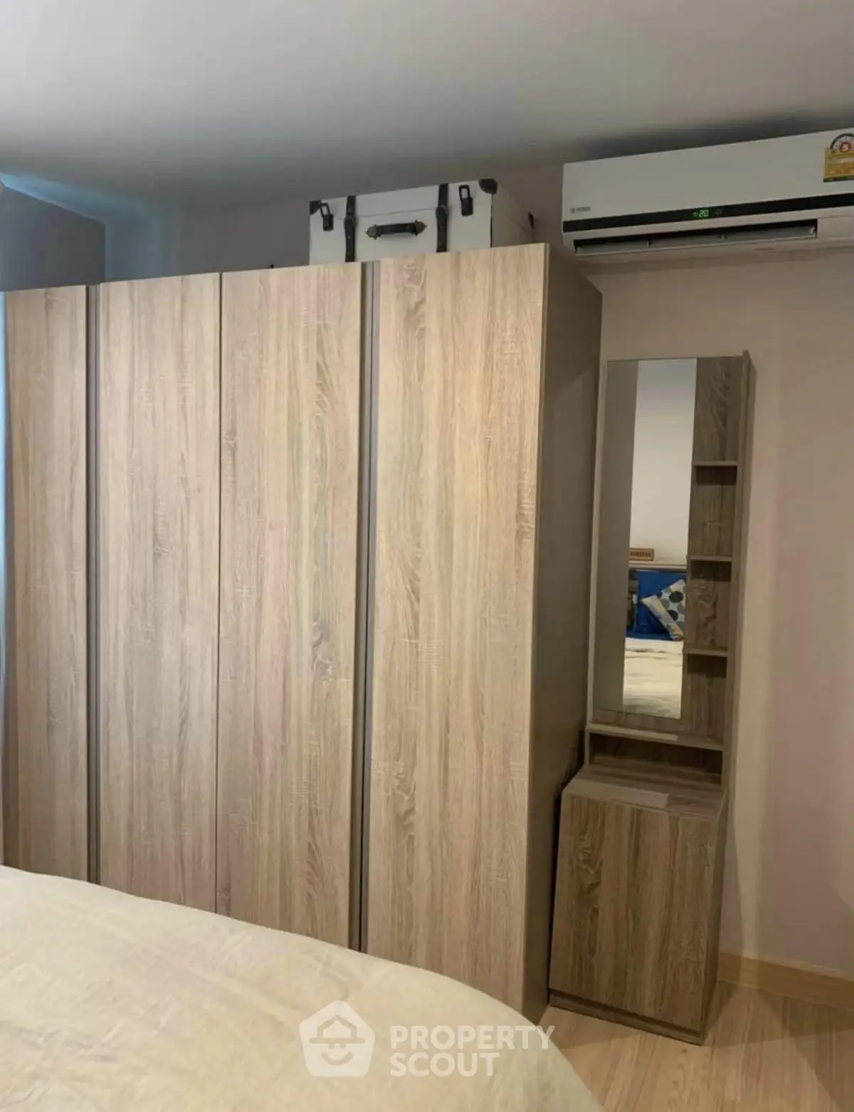 Modern bedroom with sleek wooden wardrobe and air conditioning unit, perfect for comfortable living.