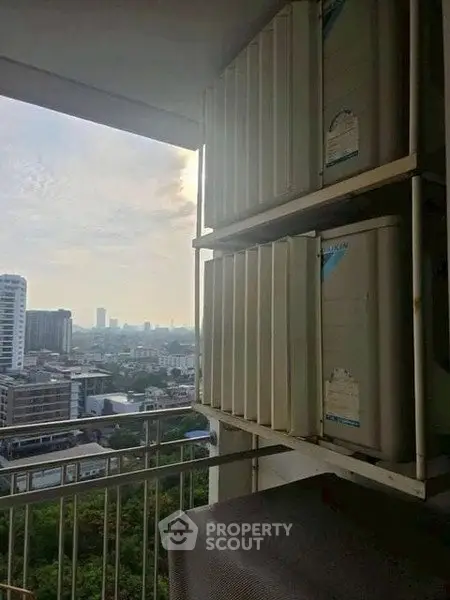 High-rise building balcony with city view and air conditioning units