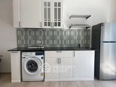 Modern kitchen with washing machine and sleek appliances in stylish apartment