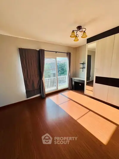 Spacious bedroom with large window and built-in wardrobe, perfect for natural light lovers.