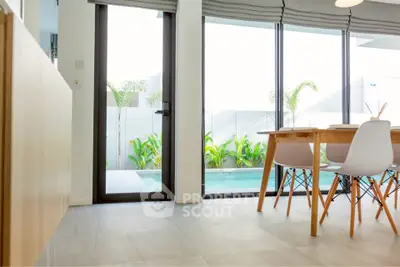 Modern dining area with pool view and stylish furniture in a bright, open space.