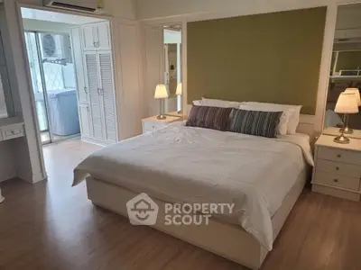 Spacious bedroom with modern decor and balcony access in a stylish apartment.