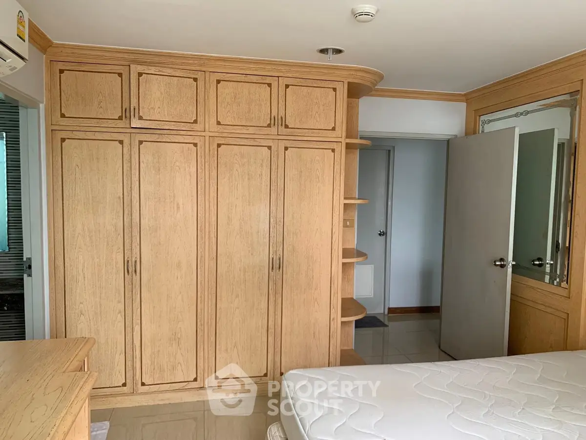 Spacious bedroom with built-in wooden wardrobe and cozy atmosphere