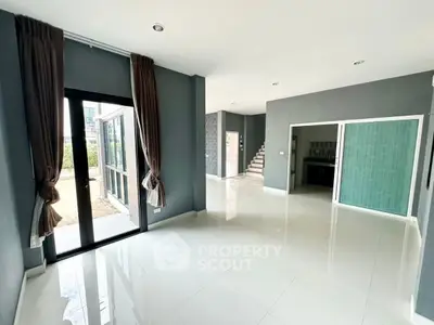 Spacious modern living room with large windows and sleek tile flooring