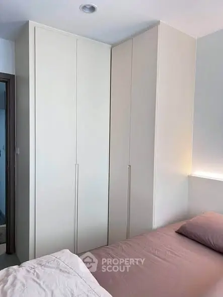Modern bedroom with sleek built-in wardrobe and cozy bedding