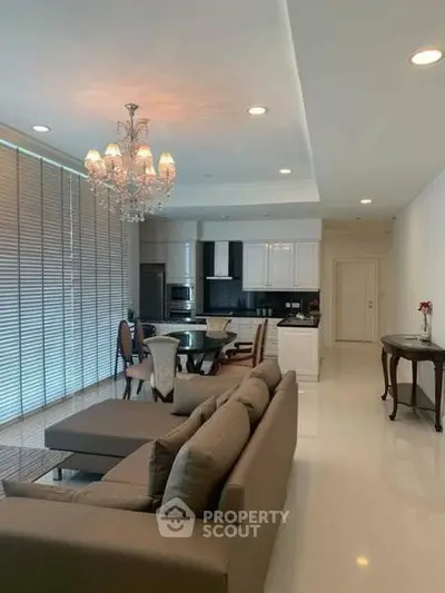 Spacious modern living room with elegant chandelier and open kitchen layout