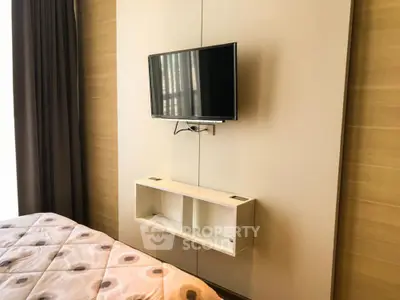 Modern bedroom with wall-mounted TV and stylish bedding