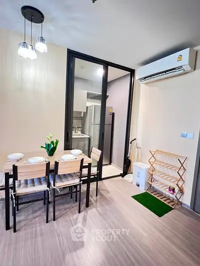 Modern dining area with sleek table, chairs, and air conditioning in a stylish apartment.