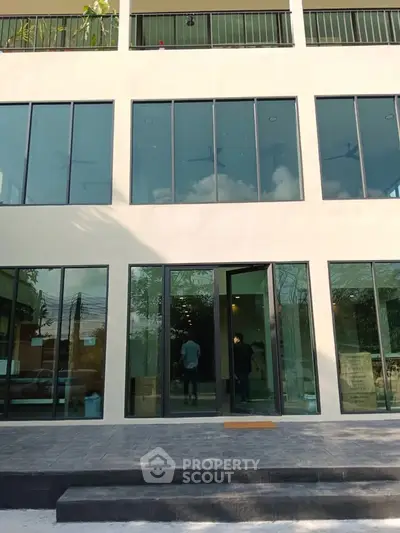 Modern building exterior with large glass windows and sleek design, perfect for commercial or residential use.