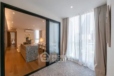 Modern open-plan living and dining area with large windows and elegant decor.
