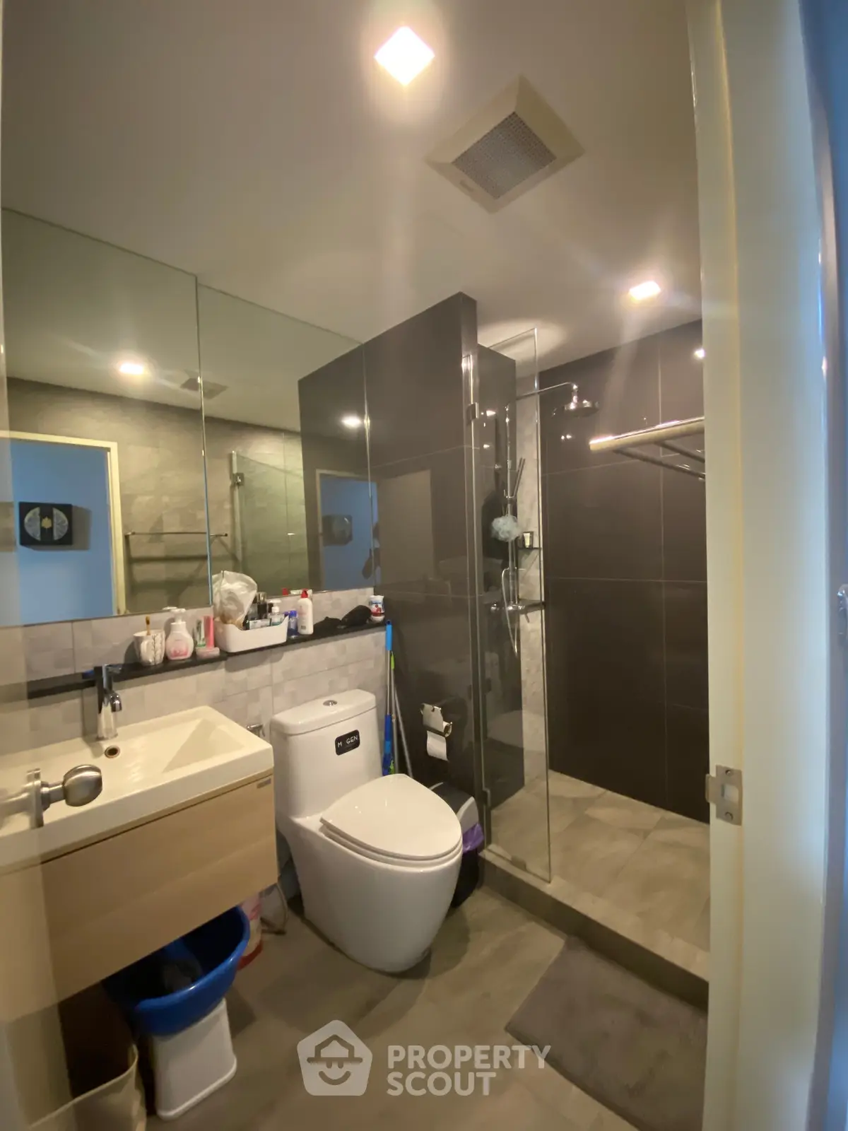 Modern bathroom with sleek design, featuring a glass shower enclosure and contemporary fixtures.