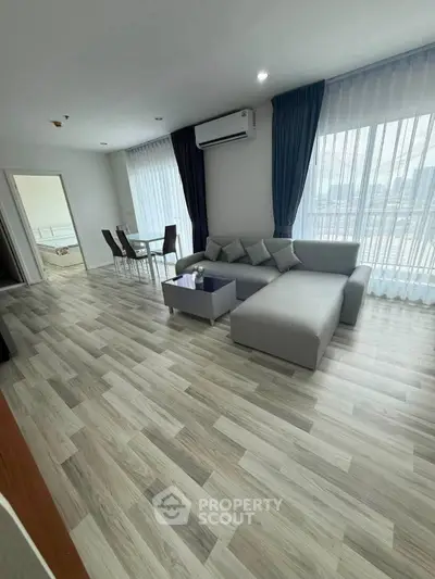 Spacious modern living room with elegant decor and large windows for natural light.
