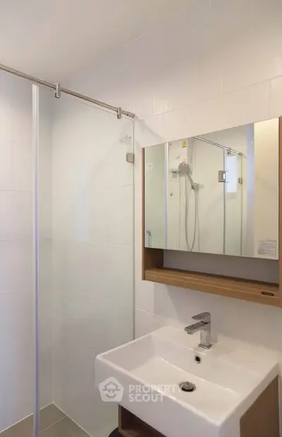 Modern bathroom with sleek shower and stylish sink in contemporary apartment.