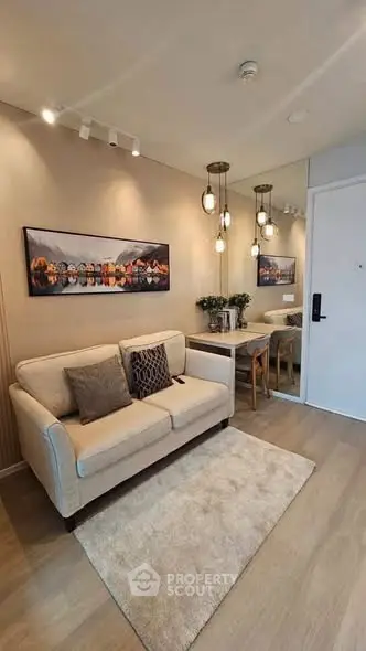 Modern living room with cozy sofa and elegant dining area, featuring stylish lighting and wall art.