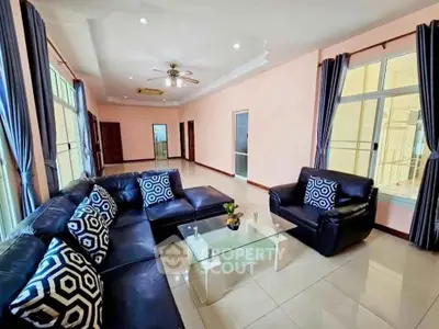 Spacious living room with modern leather sofas and large windows for natural light.