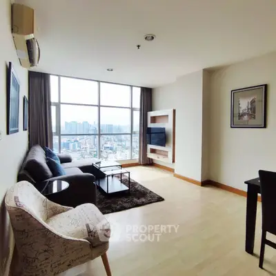 Spacious living room with panoramic city view and modern furnishings.